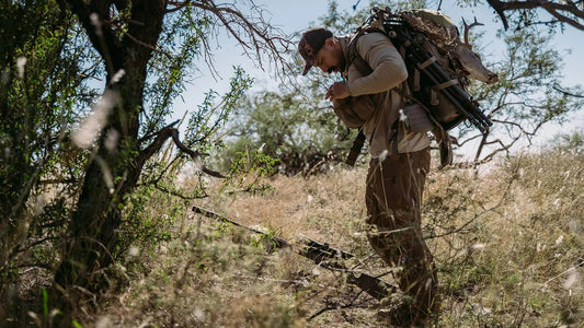 Hunter with loaded Moxule hunting backpack trekking through dry brush