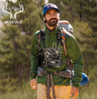 Hunter wearing Moxule camouflage binocular chest pack and hunting backpack in forest outdoor scene, 