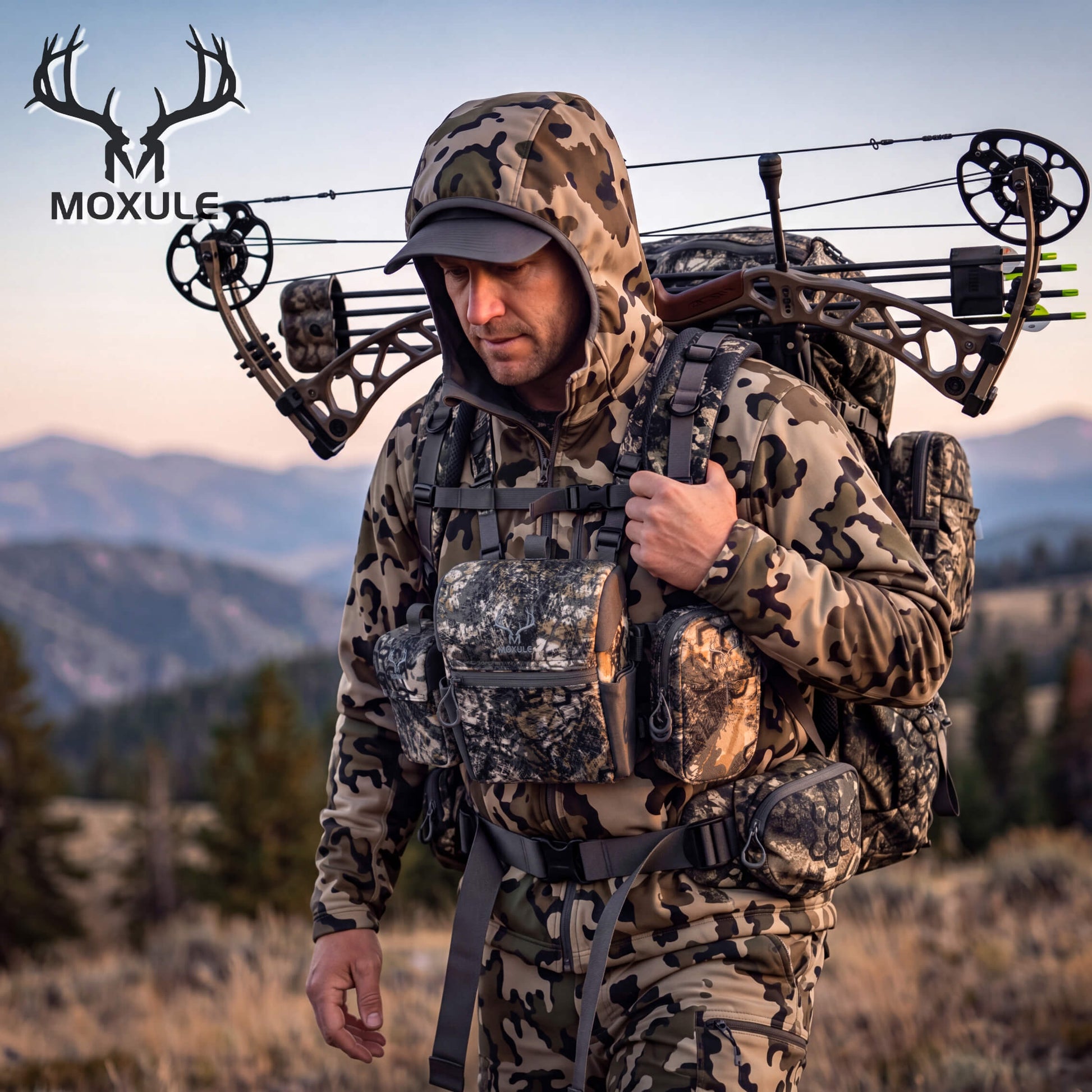 Bow hunter in camouflage outfit with Moxule bino harness and hunting pack, mountain backcountry hunting scene
