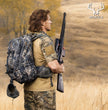 Moxule camouflage hunting backpack in use by a hunter with a rifle, designed for backcountry hunting and tactical outdoor trips