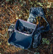 Camo binocular harness with open compartment, modular hunting chest pack for binoculars, weather-resistant bino holder with internal storage pockets.