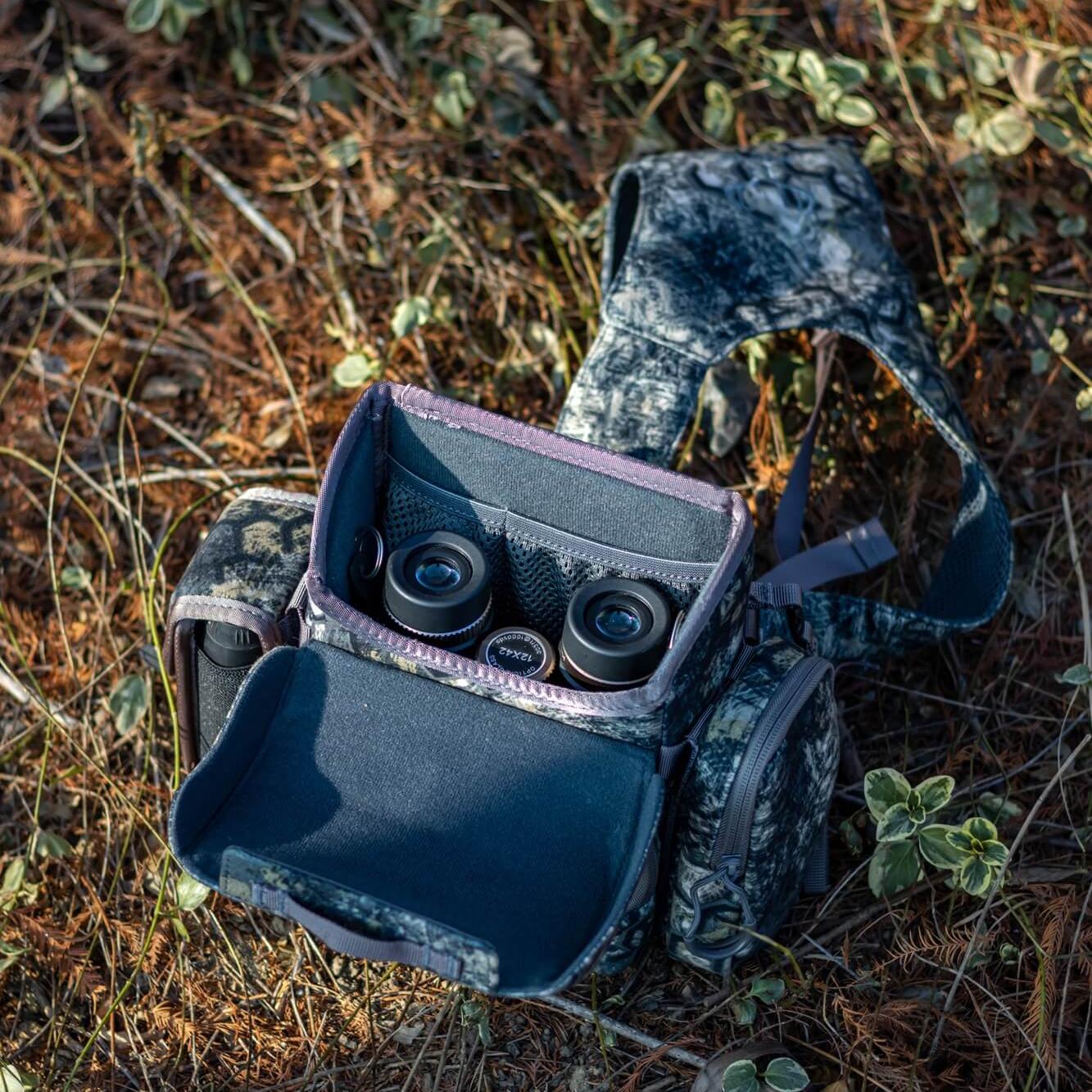 Camo binocular harness with open compartment, modular hunting chest pack for binoculars, weather-resistant bino holder with internal storage pockets.